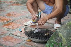 Chef using a blowtorch to cook bird in Tay Ninh City, Vietnam