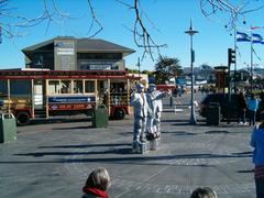 Fisherman's Wharf promenade with walking tourists and colorful shops