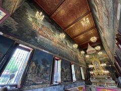 intricate interior of a small Buddhist ordination hall with statues and murals