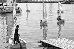 black and white image of various boats docked at a pier