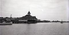 Side angled view of Balboa Pavilion and surrounding docks in Newport Beach, circa 1924