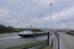 Busy ship traffic under Nescio bridge across Amsterdam-Rhine canal near IJburg