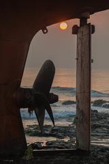 Rudder of a beached ship at sunrise