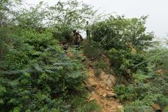 hiker descending rugged trail towards a serene lake