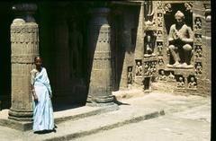 Woman standing next to a sculpture at Ajanta Caves entrance, near Aurangabad, India