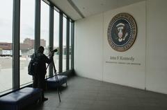 John F. Kennedy Presidential Library entrance with presidential seal and photographer