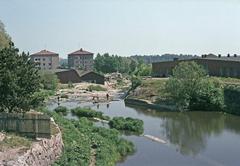 Children playing at Vanhankoski Rapids with Kuninkaankartanonsaari on the right and apartment buildings in the background on Katariina Saksilaisen Street