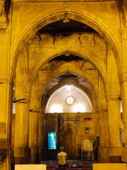 Night view of Sidi Saiyyed Mosque with a person in prayer