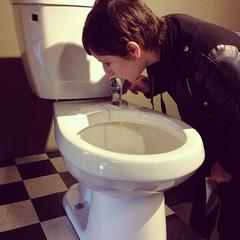 Person drinking from a toilet fountain