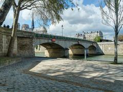 Pont de l'Archevêché in Paris with people walking and buildings in the background