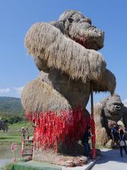 Huai Tueng Thao reservoir with huts and large animal figures made of rice stalks