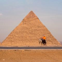 large contemporary sculpture in front of ancient pyramid