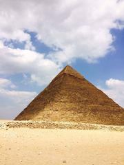 Great Pyramid of Giza under a blue sky with the sun shining