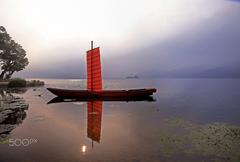 Sunrise over a tranquil lake with sunlight reflected in the water