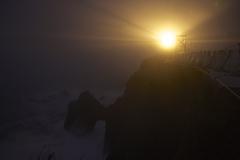 Candle in the dark fog illuminating a bridge and an arch at night