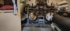 interior of a WWI Italian submarine with torpedo tubes, bunks, and a torpedo