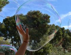 Child playing with bubbles in Parc Guell