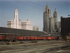 Trucks unloading at Illinois Central Railroad freight terminal in Chicago, with Wrigley Building and Tribune Tower in the background