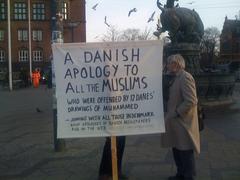 Two men holding a sign apologizing to Muslims at Copenhagen's City Hall