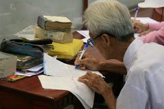 Dương Văn Ngộ writing letters at Ho Chi Minh City post office