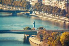 Pont de Grenelle in Paris with the Statue of Liberty and a skyline of buildings