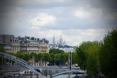 A view of Montmartre in Paris with the Basilica of the Sacré-Cœur perched atop the hill under a cloudy sky