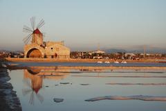 Beautiful sunset reflecting on the still waters of a salt flat in Italy