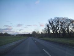 Bradenham Road in West Wycombe with trees lining the street and a glimpse of a house