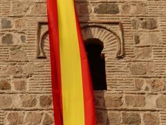 Santiago del Arrabal church with arch and flag in Toledo, Spain