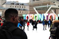 A man ice skating in Nathan Phillips Square