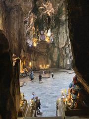 Inside the magnificent cave of Marble Mountains with sparkling light shining through golden rock formations