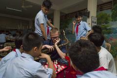 U.S. Navy musician plays chess with Vietnamese students during community engagement event