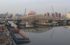 Willis Avenue Bridge reflecting on calm water on a sunny afternoon