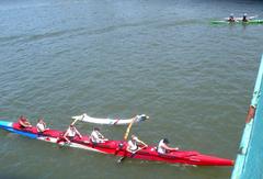 outrigger canoes under Washington Avenue Bridge on sunny day