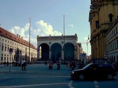 A panoramic view of Munich with historic buildings and the Alps in the background