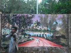 Street dweller creating graffiti on a wall in Thrissur