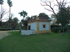 white and yellow building next to a covered well in María Luisa Park