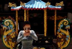 Chinese woman praying at Thean Hou Temple in Kuala Lumpur