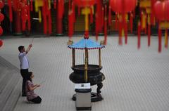 Chinese couple praying in Thean Hou Temple, Kuala Lumpur