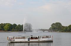 Fountain on Binnenalster Lake with the St. Georg steamship in Hamburg