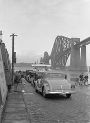 Cars by the shore of Firth of Forth with Forth Bridge on the right