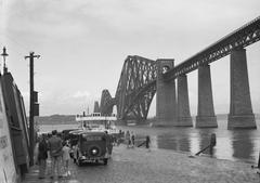 Cars by the shore of the Firth of Forth with Forth Bridge on the right