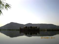 Jal Mahal reflecting on the lake with hills in the background