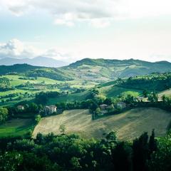 Urbino town nestled on a hillside with medieval buildings and car parks below