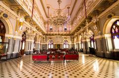 Durbar Hall of Prag Mahal in Bhuj, Gujarat, adorned with statues, art pieces, stuffed animals, chandeliers and large glass mirrors