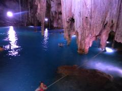 Cenote Dzitnup with natural light streaming through a hole in the ceiling