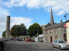 Churchyard wall in Kells, County Meath, Ireland, with Round Tower and bell tower of St Columba's Church visible