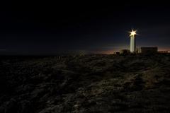 Capo Murro di Porco Faro lighthouse with rocky coastline and blue sea