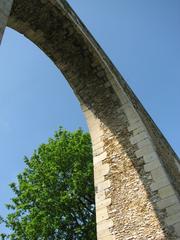 High arch of Louveciennes aqueduct with Levant tower nearby