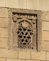 carved mosque lamp inside a window or arch